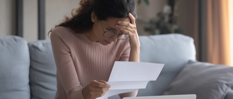 stressed young woman looking at a piece of paper