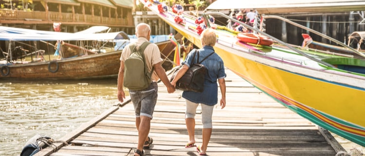 senior couple walking along a harbour jetty