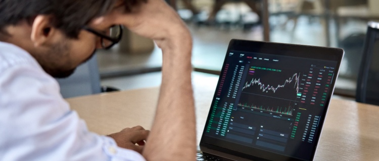 A man looking at a market index on his computer