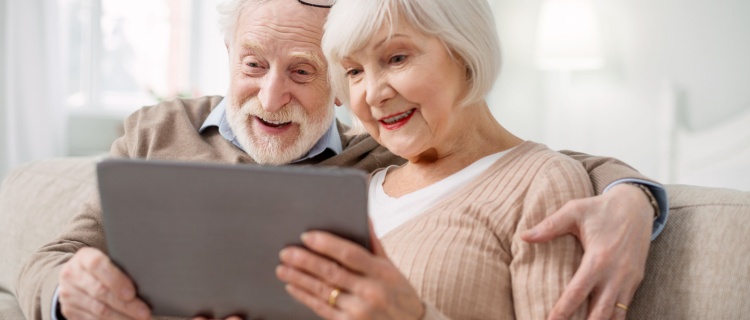 An older couple looking at a tablet together.