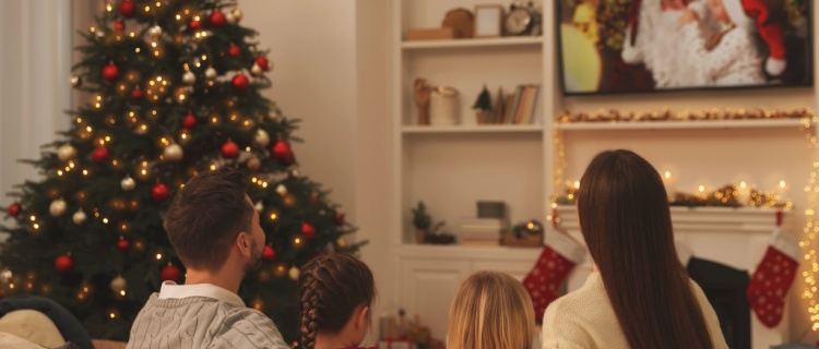 A family sitting together watching a Christmas film.