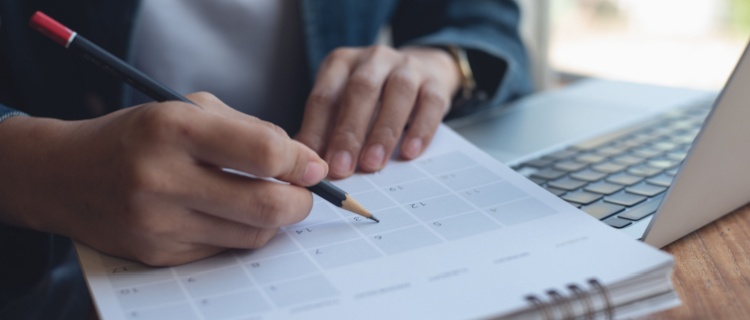 A person ticking off dates on a calendar.