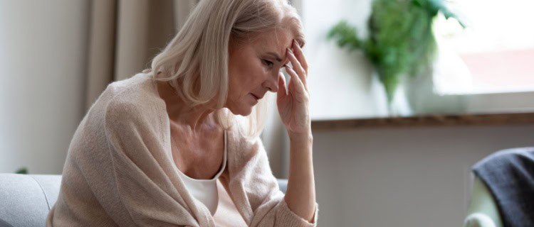 An older woman with her head in her hands.