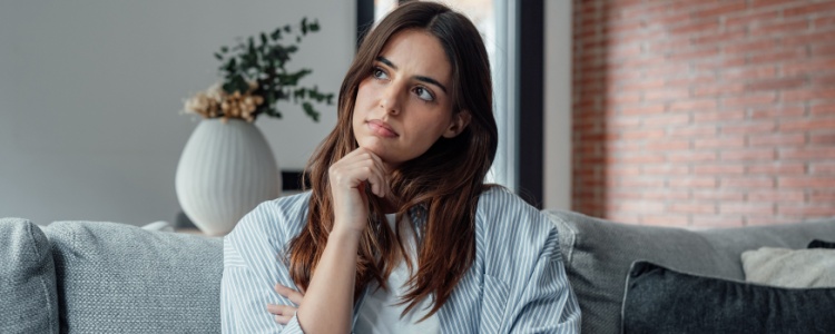 A woman at her computer, thinking.