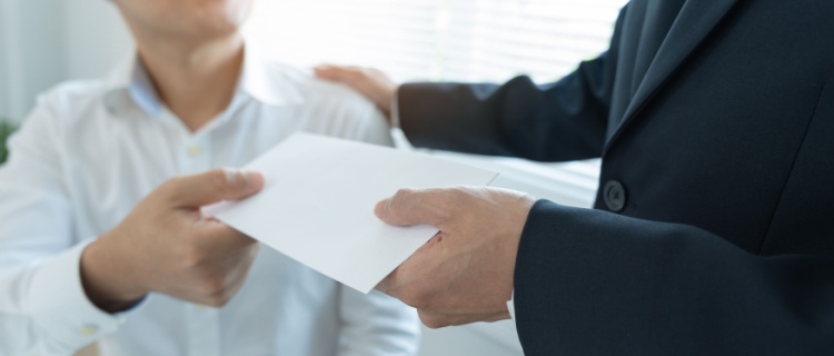 One man handing another an envelope