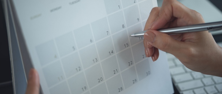 Someone writing on a calendar