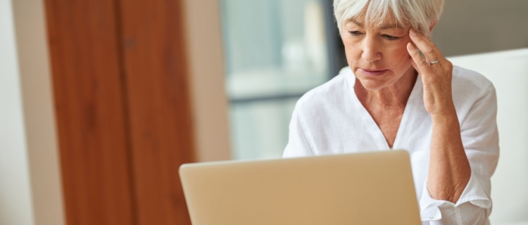 An older woman looking at a laptop