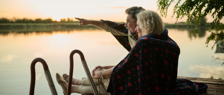 An older couple looking out across a lake
