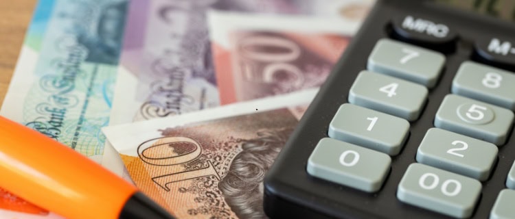 A calculator on top of some cash