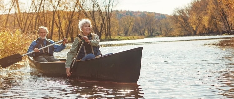 Retired couple rowing a kayak on a river